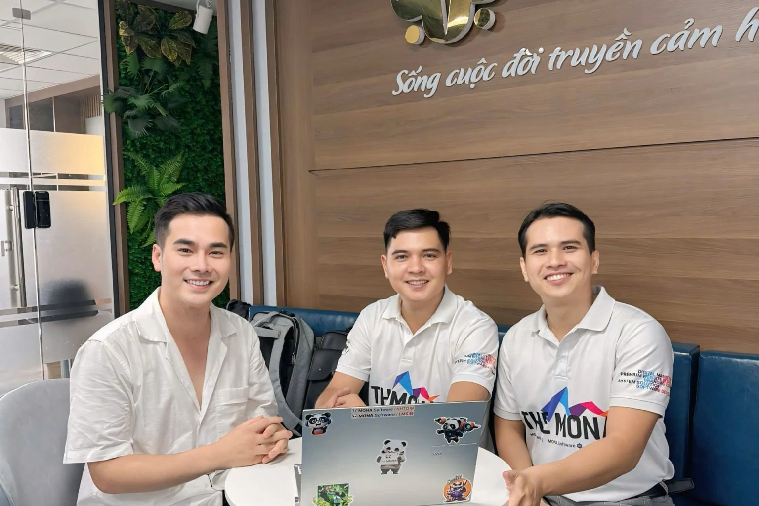 Ba nhân sự MONA mặc áo THE MONA làm việc tại văn phòng khách